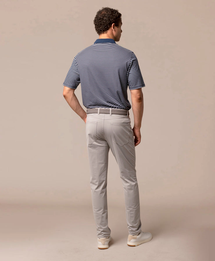 Man wearing a striped polo shirt and light gray pants