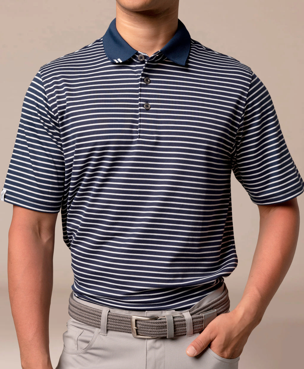 Man wearing a striped polo shirt and light gray pants