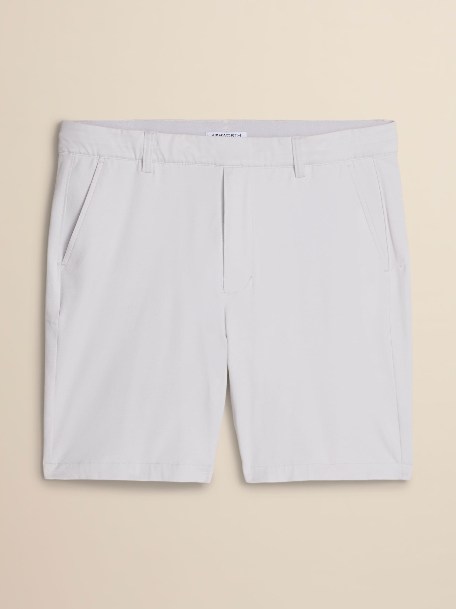 White chino shorts with a flat front and belt loops, laid flat against a light beige background.