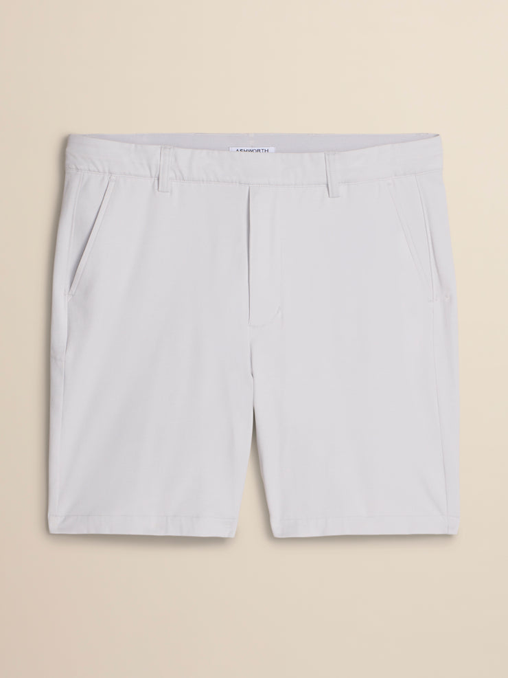 White chino shorts with a flat front and belt loops, laid flat against a light beige background.